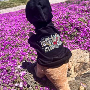 Black dog sweatshirt with The Band owl design over stuffed dinosaur prop.