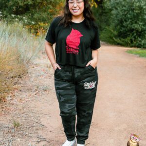 Woman in camo joggers and black tee with red owl.